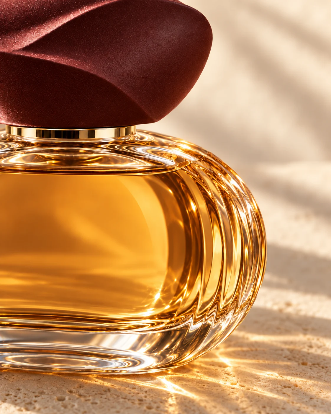 Close-up of TRACE’s folded wine-colored cap, champagne collar and fluted glass in warm light